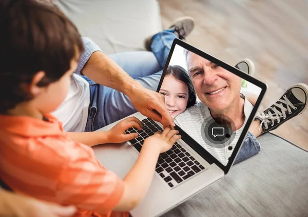 Chico teniendo una videollamada con el abuelo en el portátil — Foto de Stock