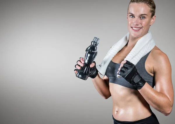 Fitness vrouw met fles water tegen de grijze achtergrond — Stockfoto