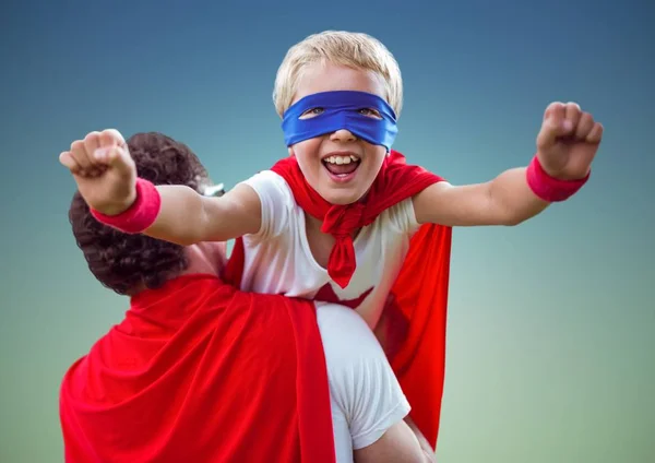 Father carrying son in super hero costume