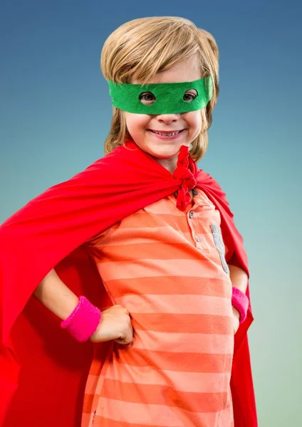 Porträt eines lächelnden Superkindes in rotem Umhang und grüner Maske — Stockfoto