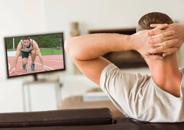 Ember ülő-on dívány néz sport csatorna — Stock Fotó