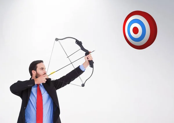 Businessman aiming at the target board against white background — Stock Photo, Image