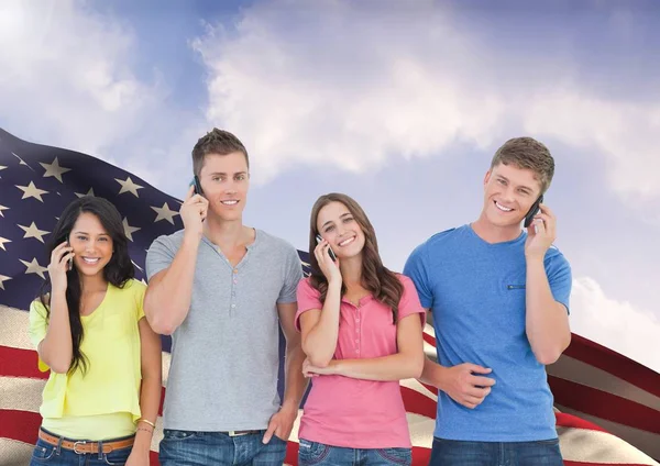 Grupo de pessoas de pé contra a bandeira americana e falando no celular — Fotografia de Stock