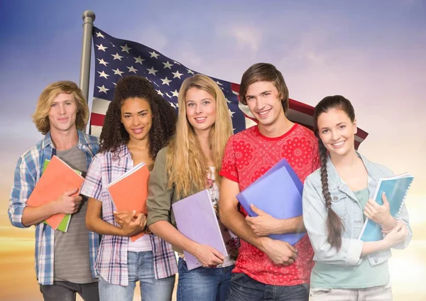 Vänner med böcker står mot amerikanska flaggan i bakgrunden — Stockfoto