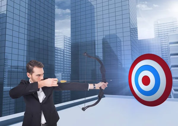 Businessman holding bow and arrow while aiming — Stock Photo, Image
