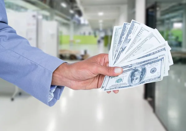 Бизнесмен держит банкноты в долларах — стоковое фото