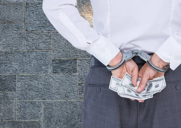 Corrupt businessman in handcuffs holding money — Stock Photo, Image