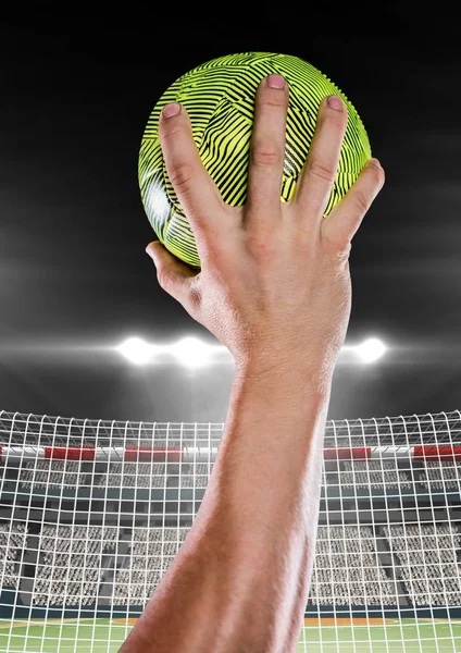 Närbild av hand som håller bollen mot målet netto — Stockfoto
