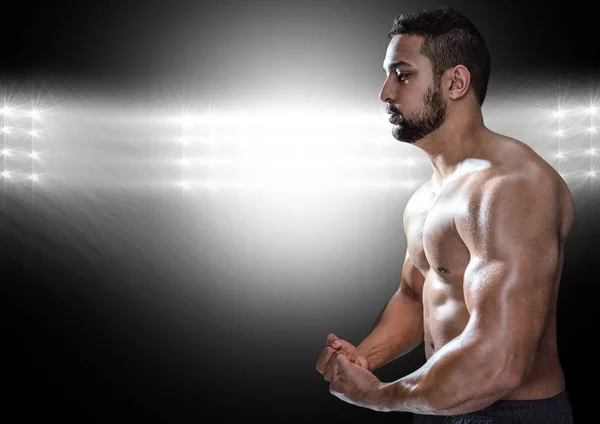 Hombre musculoso posando sobre fondo negro iluminado —  Fotos de Stock