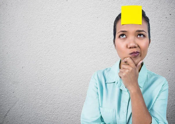 Doordachte vrouw met sticky note op haar voorhoofd — Stockfoto