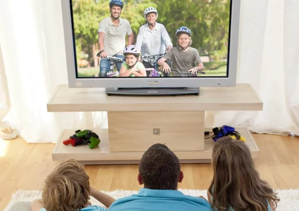 Family watching television in living room — Stock Photo, Image