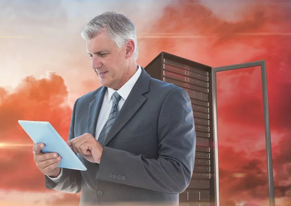 Businessman using tablet against server tower — Stock Photo, Image