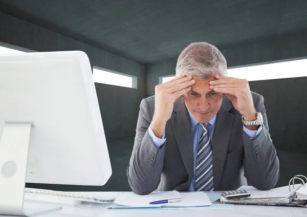 Tensed businessman sitting at desk — Stock Photo, Image