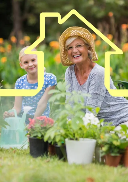 Abuela y nieta regar las plantas en el jardín contra el contorno de la casa en el fondo — Foto de Stock