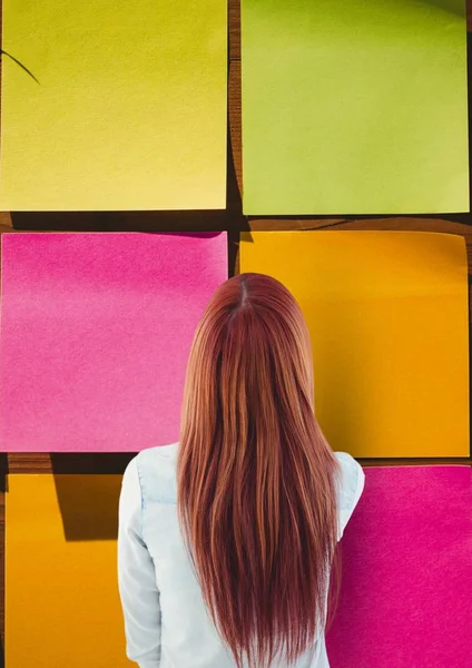 Frau blickt auf große bunte Haftnotiz — Stockfoto