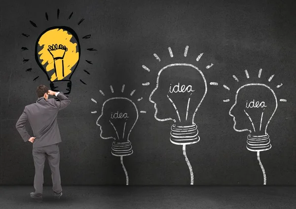 Бизнесмен смотрит на лампочку с инновационной идеей — стоковое фото