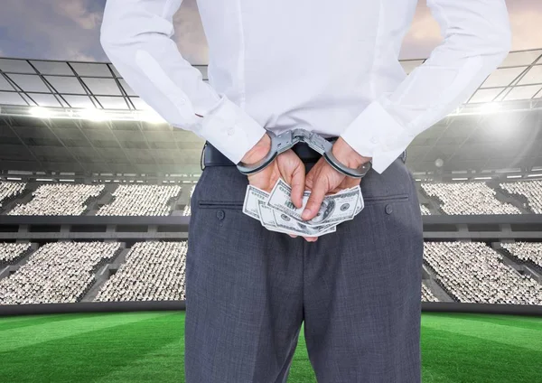 Коррумпированный бизнесмен в наручниках держит деньги — стоковое фото
