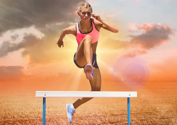 背景の空に対してハードルを飛び越える運動選手 — ストック写真