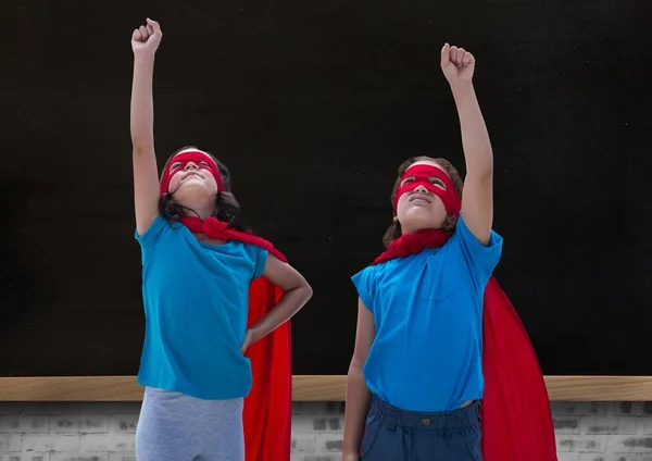 Meninas em trajes de super-herói apontando para cima — Fotografia de Stock