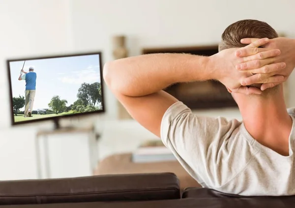 Zadní pohled člověka dívat se na televizi v obývacím pokoji — Stock fotografie