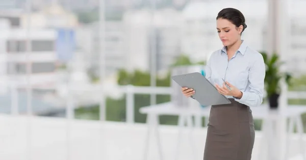Businesswoman holding a clipboard at office — Stock Photo, Image