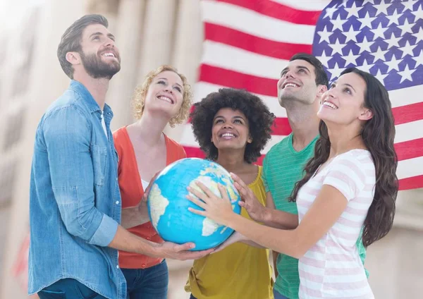 Grupo de personas felices sosteniendo el globo contra la bandera estadounidense y mirando hacia arriba — Foto de Stock