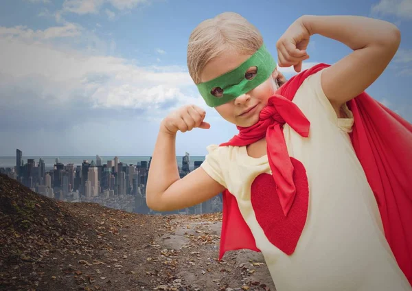 Lány szuperhős jelmezben flexing karját városkép ellen — Stock Fotó