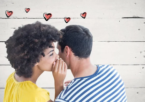 Casal sussurrando contra fundo de madeira — Fotografia de Stock