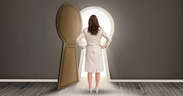 Woman standing against keyhole shaped doorway — Stock Photo, Image