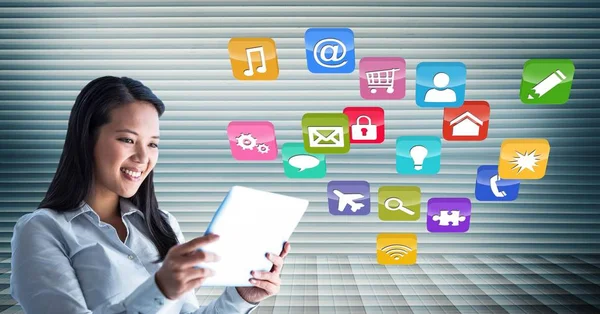 Woman using digital tablet against application icons in background — Stock Photo, Image