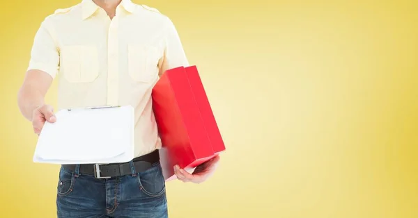 Delivery man holding a parcel and clipboard — Stock Photo, Image
