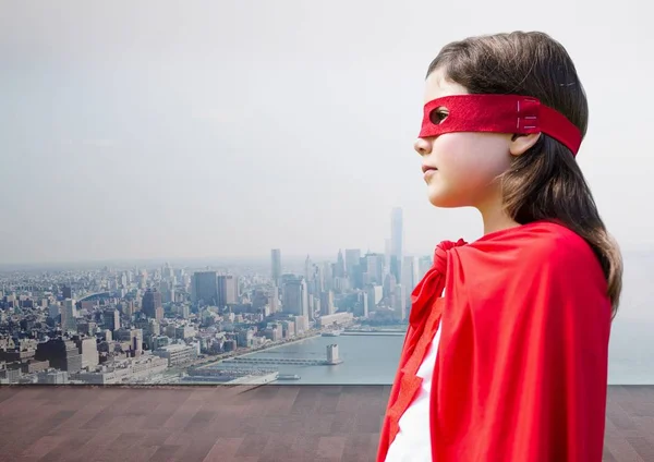 Mädchen im Superheldenkostüm vor Stadtbild-Hintergrund — Stockfoto