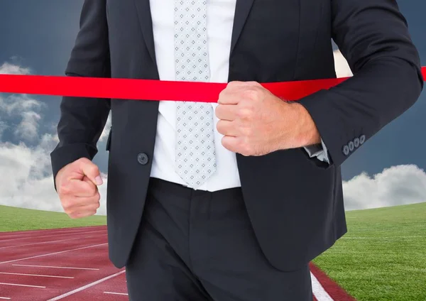 Businessman crossing finish line during race — Stock Photo, Image