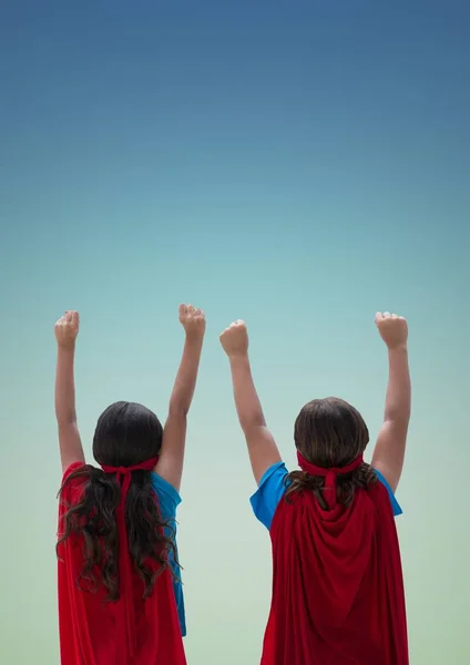 Niños en capa roja y máscara de pie con puño contra fondo turquesa —  Fotos de Stock