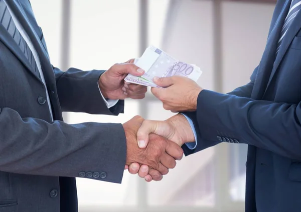 Businessmen shaking hands and receiving money — Stock Photo, Image
