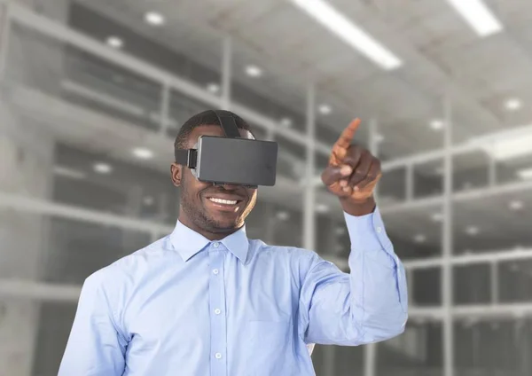 Man met behulp van virtual reality headset tegen kantoor in achtergrond — Stockfoto
