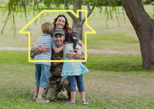 Familia abrazándose en el parque contra el contorno de la casa en el fondo —  Fotos de Stock