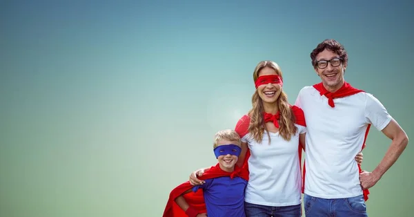Père, mère et fils en costume de super-héros debout sur fond vert — Photo