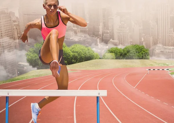 Vrouwelijke atleet boven de hindernis springen — Stockfoto