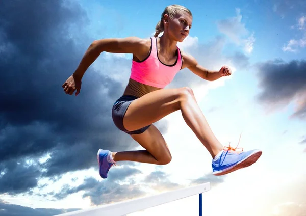 Atleta pulando sobre um obstáculo — Fotografia de Stock