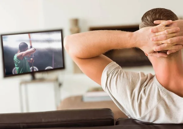 Zadní pohled člověka dívat se na televizi v obývacím pokoji — Stock fotografie