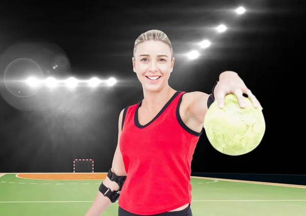 Retrato de jogador de handebol feminino feliz segurando bola no campo de handebol — Fotografia de Stock