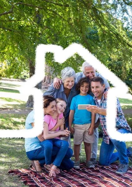 Familia multigeneración tomando un selfie al aire libre contra el contorno de la casa en el fondo — Foto de Stock