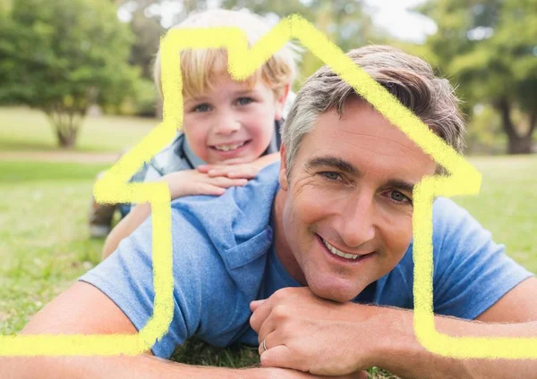 Pai e filho coberto com forma de casa deitado no parque — Fotografia de Stock