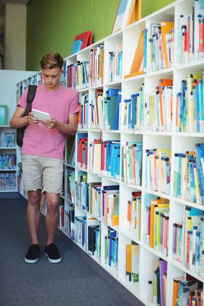 Attente schooljongen via tablet in bibliotheek — Stockfoto