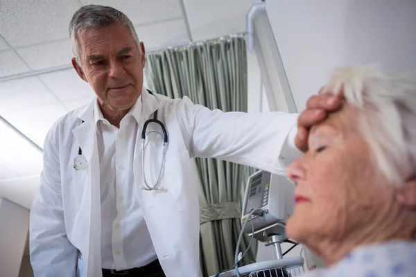 Doctor examining senior patient in ward — Stock Photo, Image