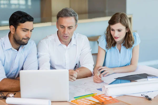 Arquitectos discutiendo sobre portátil en sala de conferencias — Foto de Stock