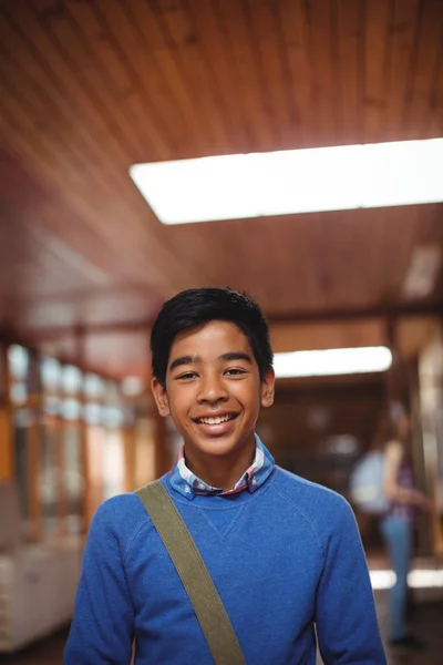 Smiling schoolboy standing in corridor — Stock Photo, Image