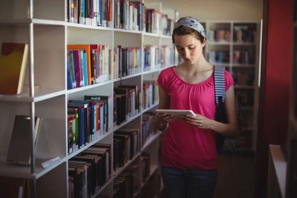 Figyelmes iskolás segítségével digitális tabletta, könyvtár — Stock Fotó