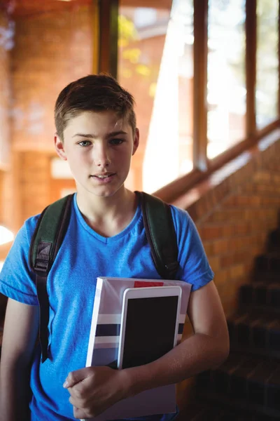 Школьник с цифровым планшетом и книгой — стоковое фото